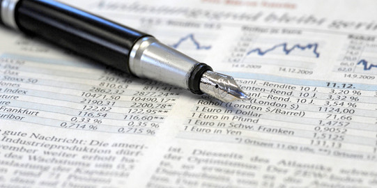 Börsenzahlen Eine Zeitung mit Informationen zur Börse und ein Füllfederhalter liegt darauf.